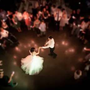 Bride and groom dancing while wedding guests form a circle around them